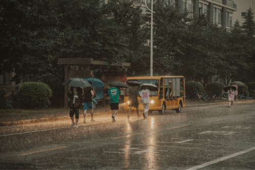 People outside with umbrellas during a monsoon